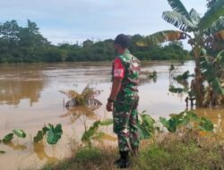 Pantau Debit Air Sungai di Wilayah Binaan, Babinsa Koramil Muara Bengkal Imbau Warga Tetap Waspada